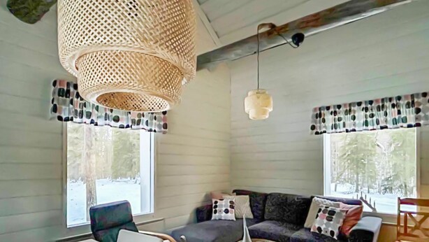 A cozy living room with a sofa, chairs, a coffee table, and a hanging light fixture. - Pajalan piilopirtti by Interhome (Kuusamo)