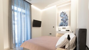 Ein modernes Hotelzimmer mit einem großen Bett, einem flachbildfernseher an der Wand und einer dekorativen Wandgestaltung.