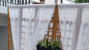 Ein Patio mit Tisch und Stühlen, einer Holzzakku und Kübelpflanzen.