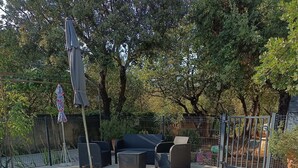 A swimming pool with tiled edges, surrounded by outdoor furniture and a fence. - La Chenaie (Mazan)