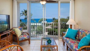 A balcony with a view of the ocean, furnished with a sofa, chairs, and a coffee table. - Puako Condo 403 ~ 3 BR Ocean View ~ Pool ~ Puako (Waimea)