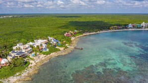 An aerial view of a coastal area with buildings, a beach, and clear waters. - Stunning 5BR Balam Ek Villa – Oceanfront, Pool & Exceptional Views (Akumal)