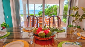A dining table set for four with a view of the ocean. - Stunning 5BR Balam Ek Villa – Oceanfront, Pool & Exceptional Views (Akumal)