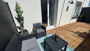 A patio with a sofa set, a table, and a potted plant. - Apartment with terrace and private parking in Concarneau, Brittany (Concarneau)