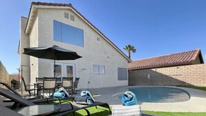A house with a swimming pool, outdoor furniture, and a patio area. - Cheerful 3-Bedroom home w/ Pool(minutes to the Strip) (Las Vegas)