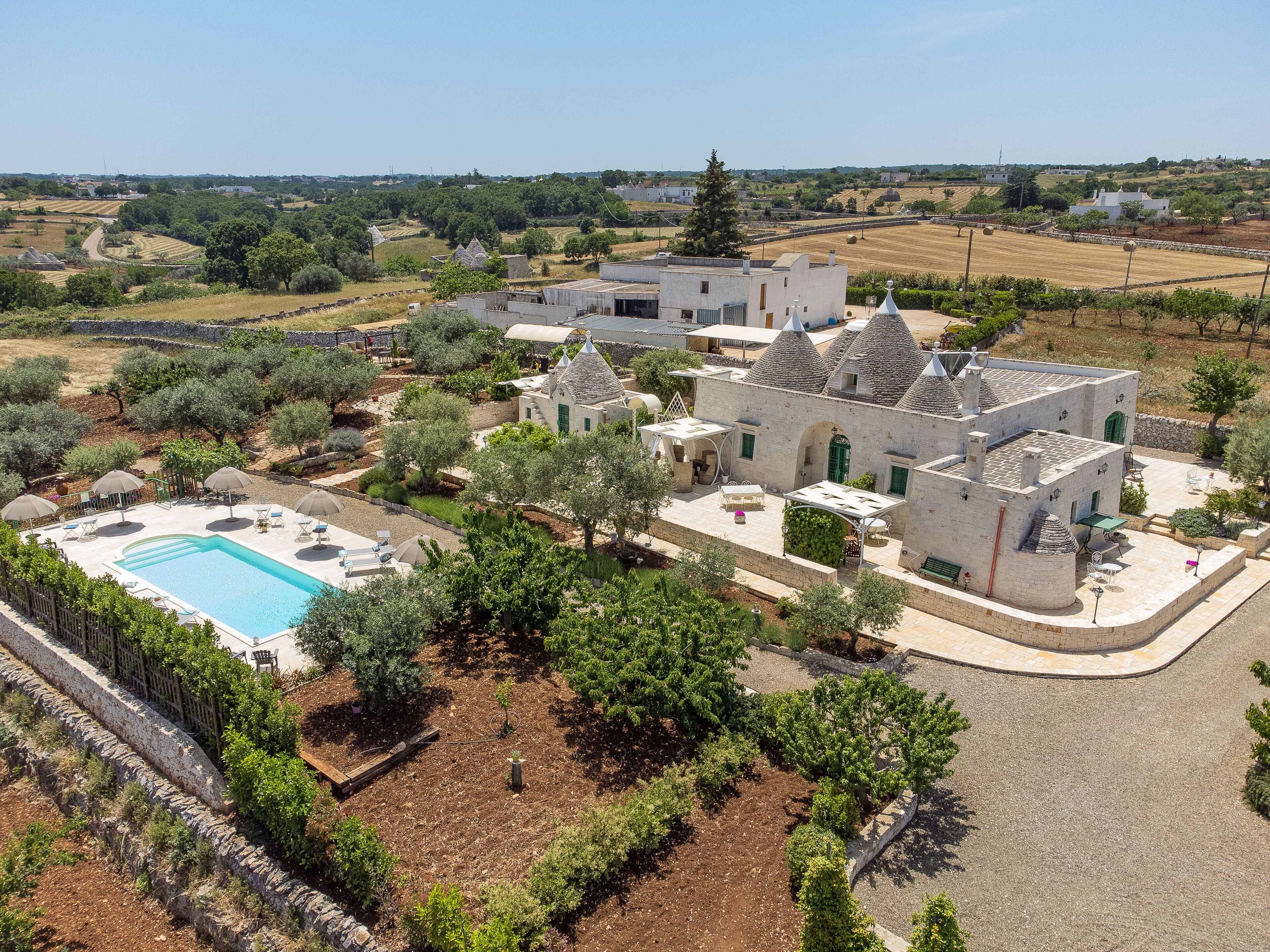 A villa with a swimming pool, outdoor seating, and a garden.