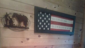 Een houten wand met een lijst met de Amerikaanse vlag en een silhouet van een paard.