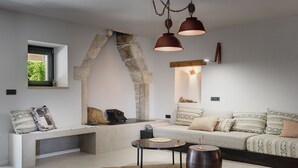 Una sala de estar moderna con un arco de piedra, un banco, un sofá y una mesa de centro.