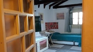 A room with a checkered floor, a bed, a desk, and a window with curtains. - La Casita Azul 1. Your corner in the country. (La Estación de Puerto Lumbreras)