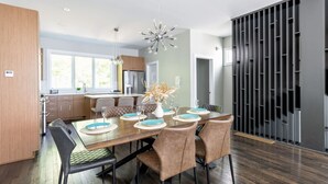 Un comedor moderno con una mesa de madera, sillas acolchadas y un centro de mesa decorativo.