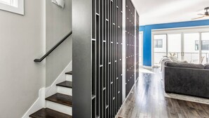 Un interior moderno con una escalera, un panel decorativo y una sala de estar con un sofá.