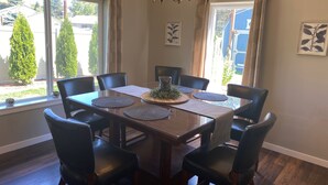 Ein Esszimmer mit Holztisch, sechs Stühlen und einer Chandelier.