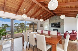 Enjoy meals in this dining area with a wooden ceiling, a dining table, and comfortable seating for relaxation.