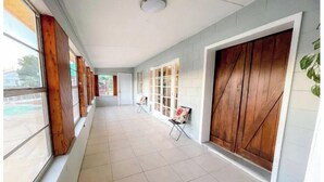 A corridor with tiled flooring, large windows, and wooden doors. - DIRECT Gulf View/Access! KAYAKS!!! WATERFRONT!!! (Hernando Beach)
