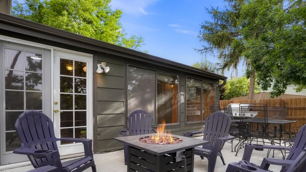 An outdoor patio with Adirondack chairs, a fire pit, and a grill area. - Newly Renovated-Spacious-20min to Den& Boulder-HotTub/Game Room/Basketball Court (Westminster)