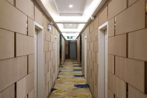 A hotel corridor with a tiled floor and a ceiling light fixture. - Yanjin Jinzuo Mingdu Hotel (Yanjin)