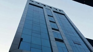 Un edificio alto con fachada moderna de vidrio y diseño simétrico.