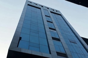 A tall building with a modern glass facade and a symmetrical design. - Yanjin Jinzuo Mingdu Hotel (Yanjin)