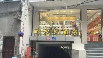 A building with a sign that reads 'Sheng Long Liquor Store' and a 'No Parking' sign below it.
