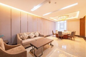 A modern hotel room with a sofa, chairs, a dining table, and a chandelier. - Taibai Mountain Wanguo Hotel (Mei County)