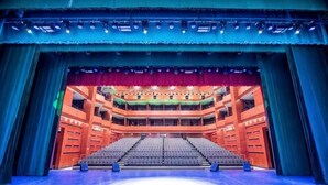 An indoor theater with multiple levels of seating, a central stage, and a blue-lit ceiling. - Taibai Mountain Wanguo Hotel (Mei County)