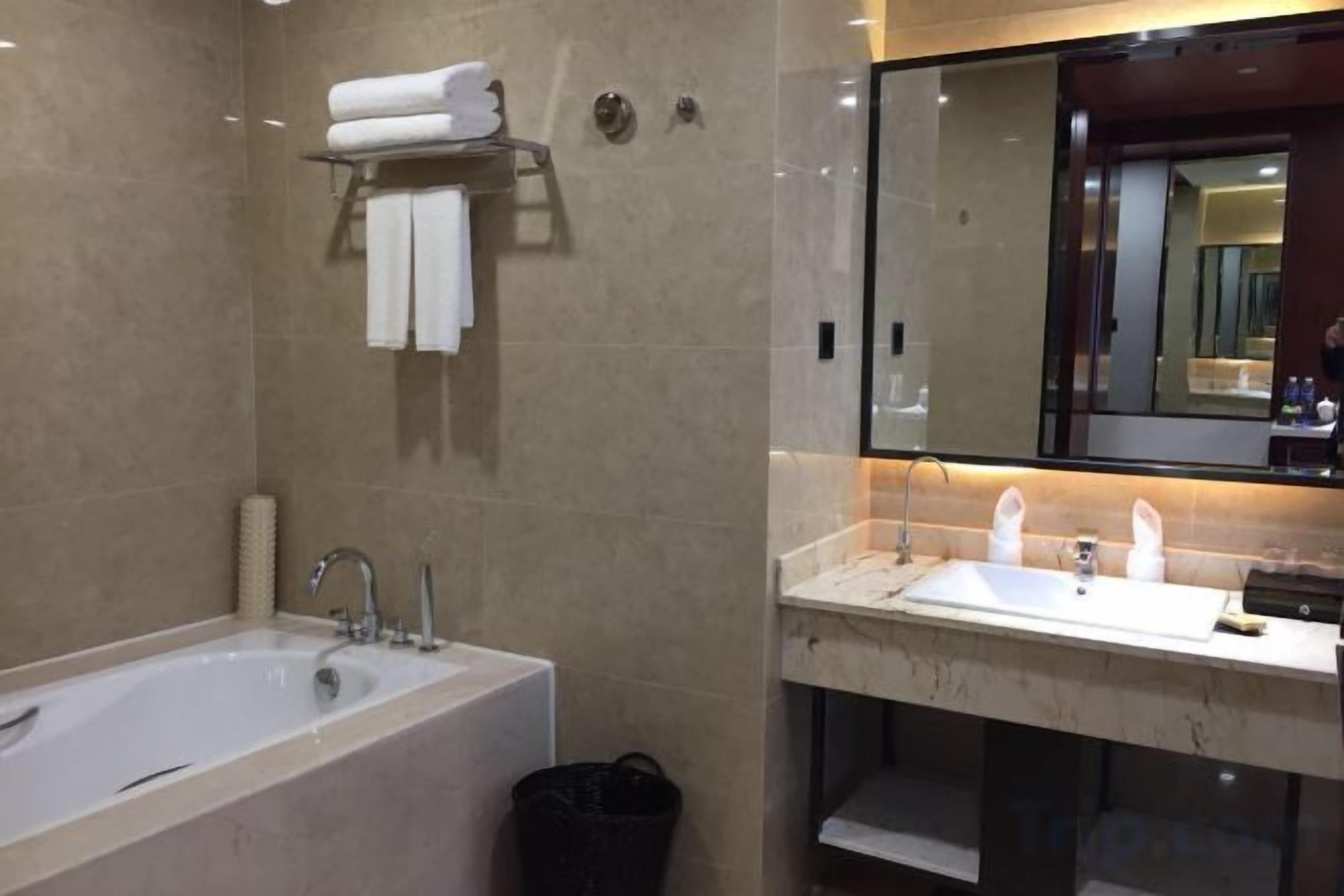A modern bathroom with a bathtub, a sink, and a mirror.