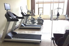 A gym with treadmills, elliptical machines, and a stationary bike. - Taibai Mountain Wanguo Hotel (Mei County)
