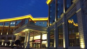 A hotel with a grand entrance, multiple floors, and a well-lit facade. - Taibai Mountain Wanguo Hotel (Mei County)