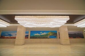 Un espacio interior con una zona amplia, un techo con una lámpara original y un mural en la pared.