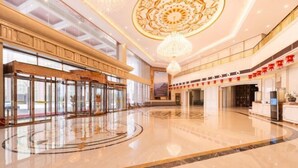 A spacious lobby with a marble floor, a grand chandelier, and a reception desk. - Taibai Mountain Wanguo Hotel (Mei County)