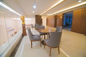 A conference room with a round table and chairs, a glass partition, and a wooden door. - Taibai Mountain Wanguo Hotel (Mei County)