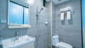 Un baño con lavamanos, espejo, ducha e inodoro.