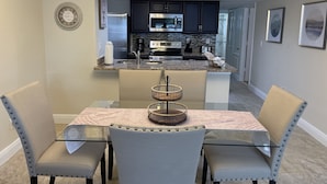 A modern kitchen with dark cabinets, stainless steel appliances, and a marble countertop. - LOVELY LUXURY APARTMENT CLOSE DISNEY (Kissimmee)