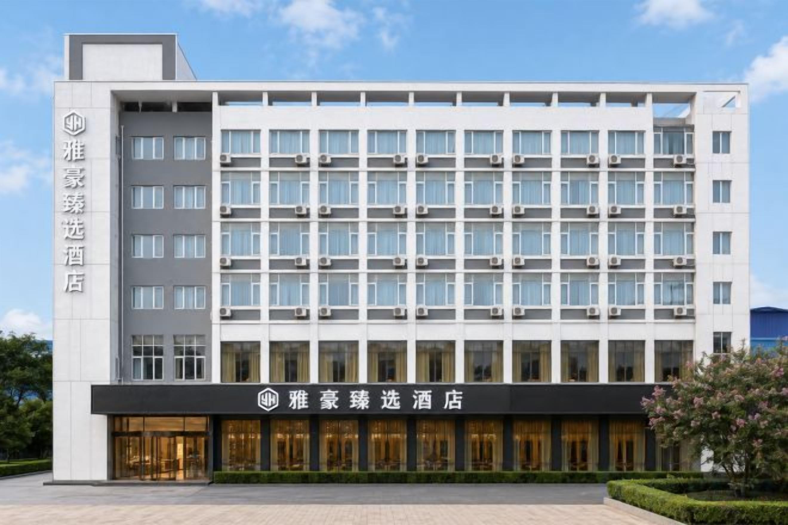 A modern hotel building with multiple floors, large windows, and a prominent entrance.