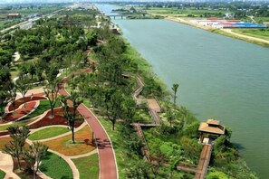 A riverside park with walking paths and a small pavilion. - Yahao Selected Hotel (Jinfeng Branch) (Zhangjiagang)