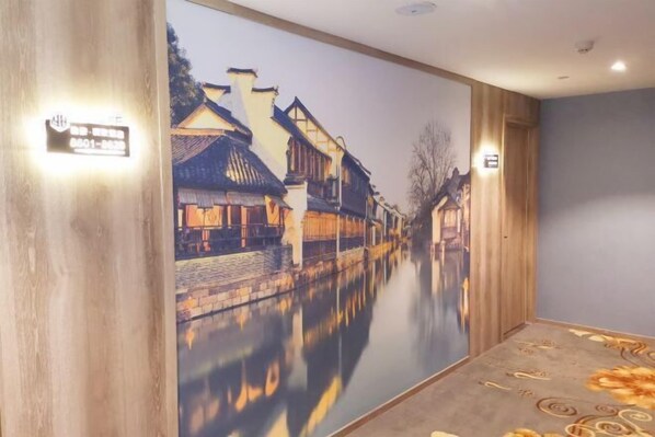A hallway with a mural of a traditional street scene, a wooden floor, and a carpet with floral patterns. - Yahao Selected Hotel (Jinfeng Branch) (Zhangjiagang)