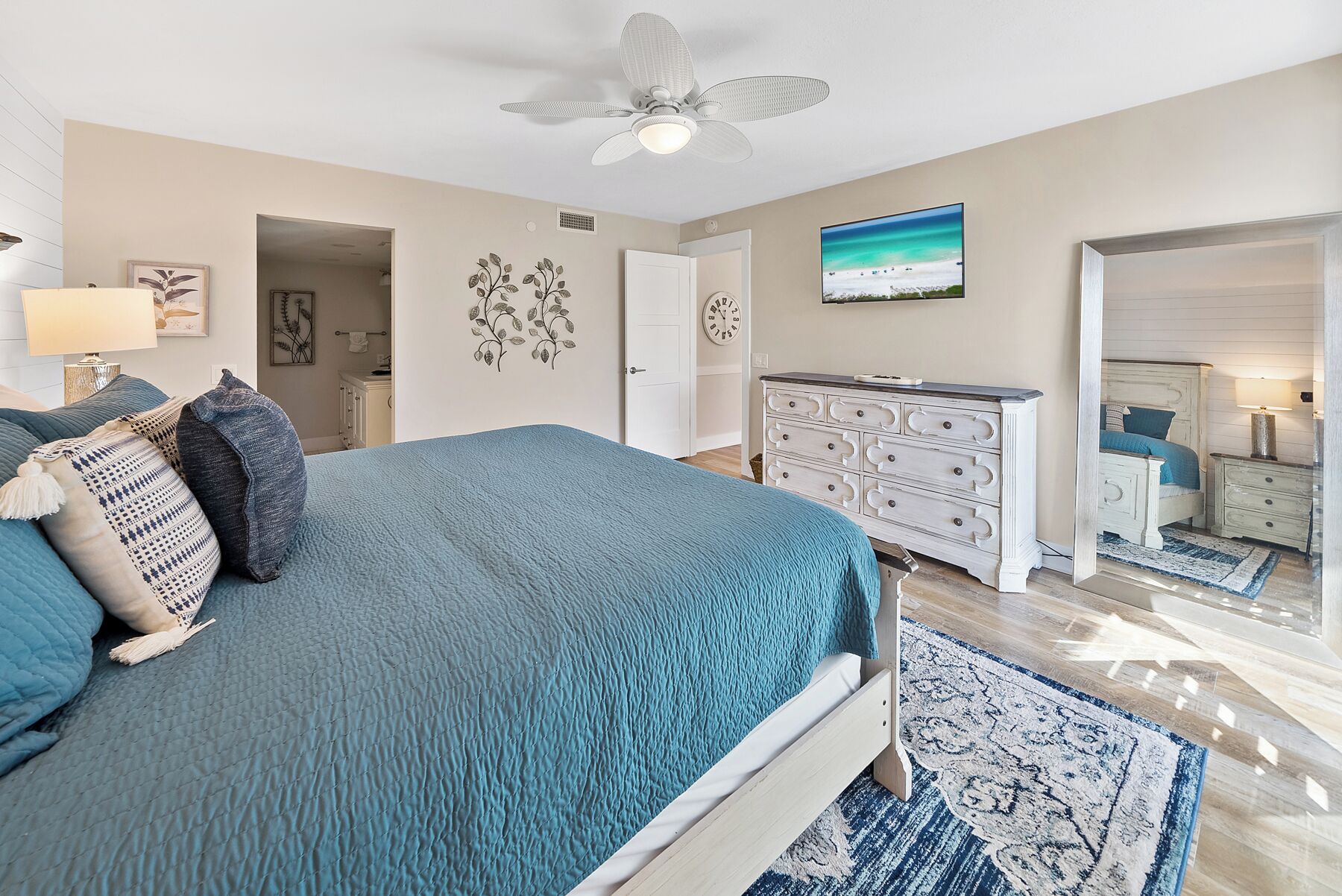 Une chambre à coucher avec un lit, une commode et un téléviseur fixé au mur.