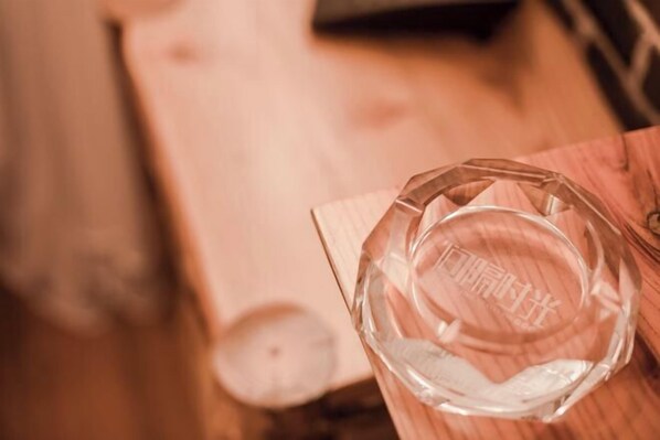 A clear glass bowl on a wooden surface with a blurred background. - JIAN GE SHI GUANG TRAVEL HOTEL(Zhangjiajie Tianmenshan Cableway Station) (Zhangjiajie)
