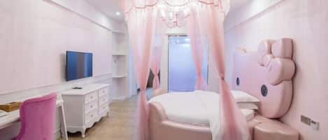 A bedroom with a round bed, a vanity with a mirror, a pink chair, and a television on a white dresser.