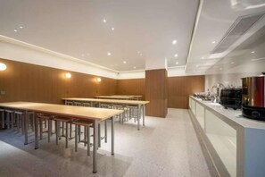A conference room with tables and chairs, a kitchenette, and a large window. - JIAN GE SHI GUANG TRAVEL HOTEL(Zhangjiajie Tianmenshan Cableway Station) (Zhangjiajie)