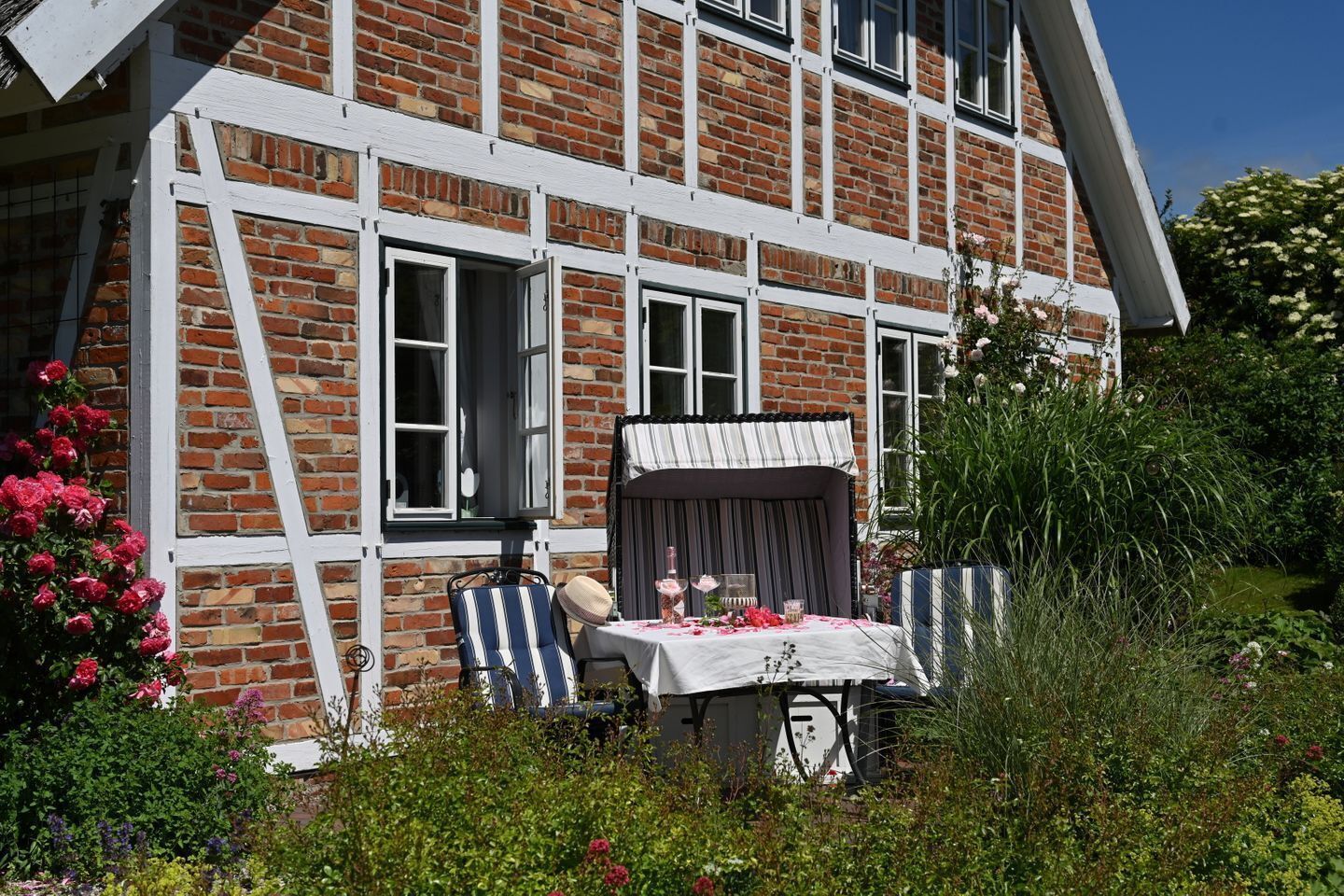 A two-story brick house with white trim and a covered outdoor seating area.