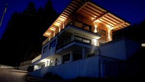 A multi-story building with balconies and a covered outdoor area, surrounded by trees. - Lovely apartment for 4 guests with WIFI, TV and panoramic view (Stumm)