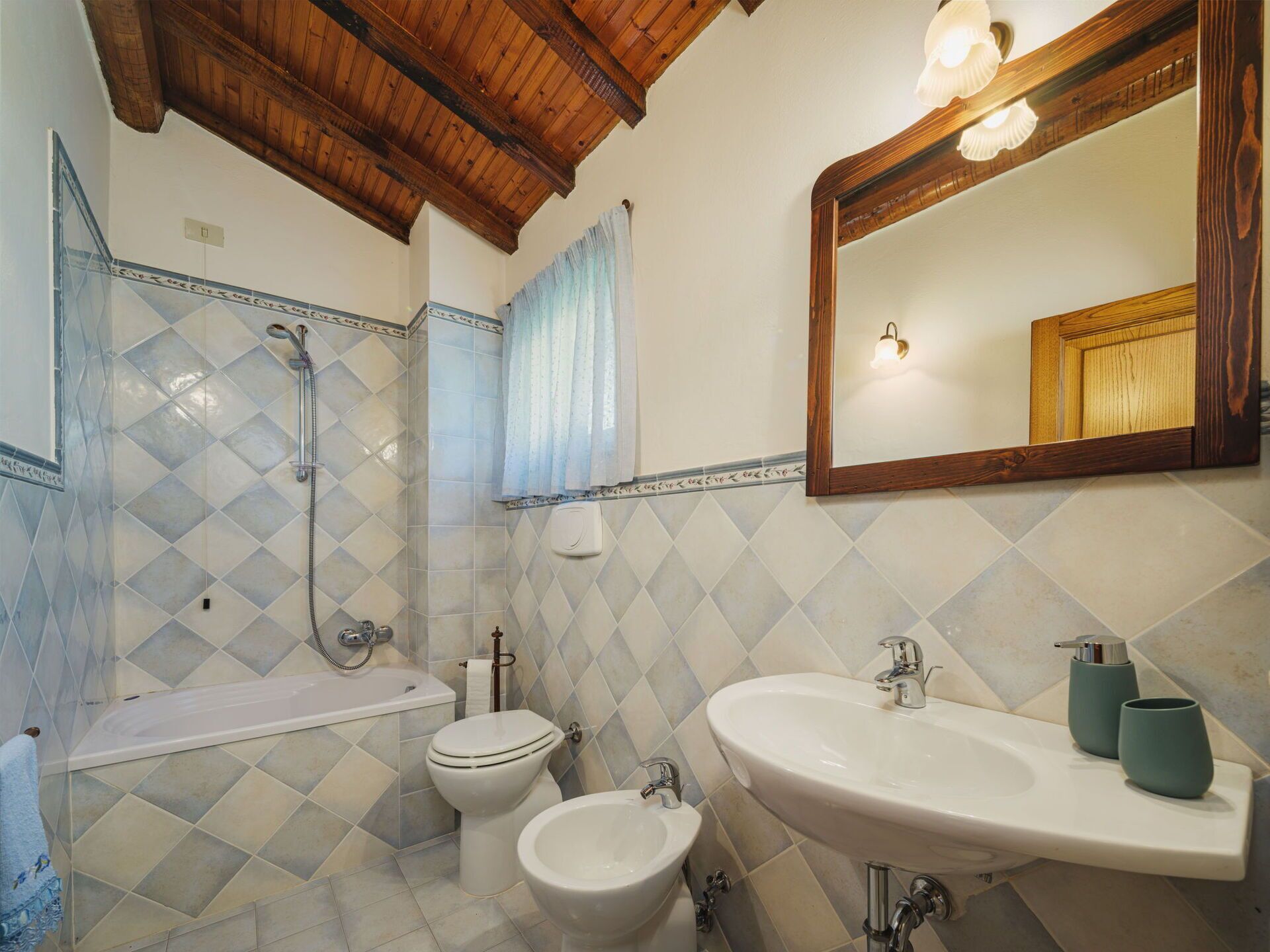 Ein Badezimmer mit einer Badewanne, zwei Toiletten, einem Waschbecken und einem großen Spiegel.