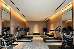 A modern gym with treadmills, dumbbells, and a bench. - Xundian Fengyi Hotel (Tangdian Passenger Transport Terminal) (Xundian)