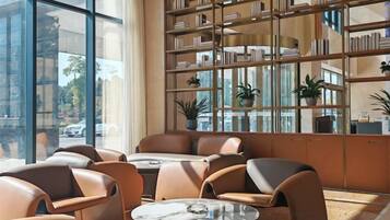 A modern interior with leather seating, a coffee table, and a bookshelf with plants.