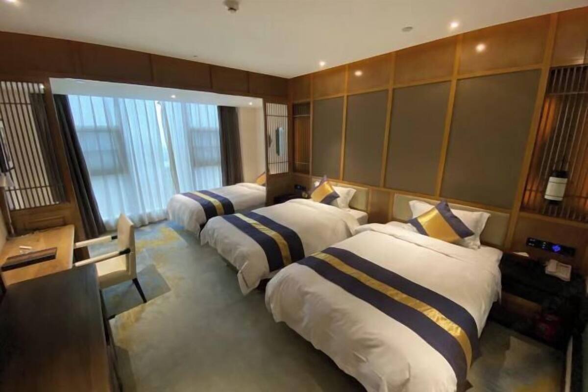 Une chambre d’hôtel avec deux lits, un bureau et une chaise.