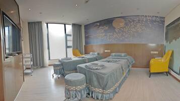 Une chambre d’hôtel avec un grand lit, un bureau et une chaise. Il y a une fenêtre avec des rideaux, une fresque murale et un téléviseur.