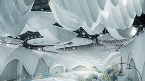 An interior with a circular central area, white drapery, and floral arrangements. - Qianshan Heyue Hotel (Suiyang)