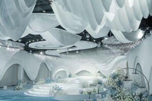 An indoor space with a central circular water feature, surrounded by seating areas and decorative plants. - Qianshan Heyue Hotel (Suiyang)