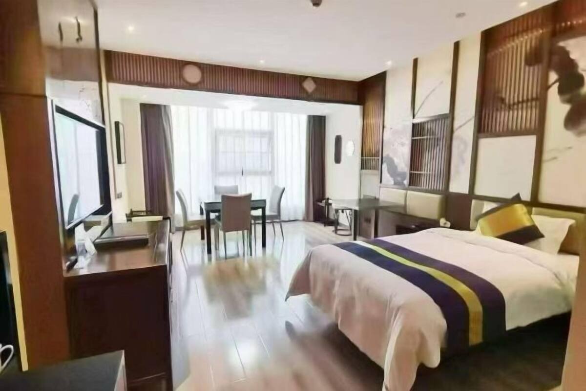 Une chambre d’hôtel équipée d’un lit, d’un bureau, d’une chaise et d’un téléviseur.